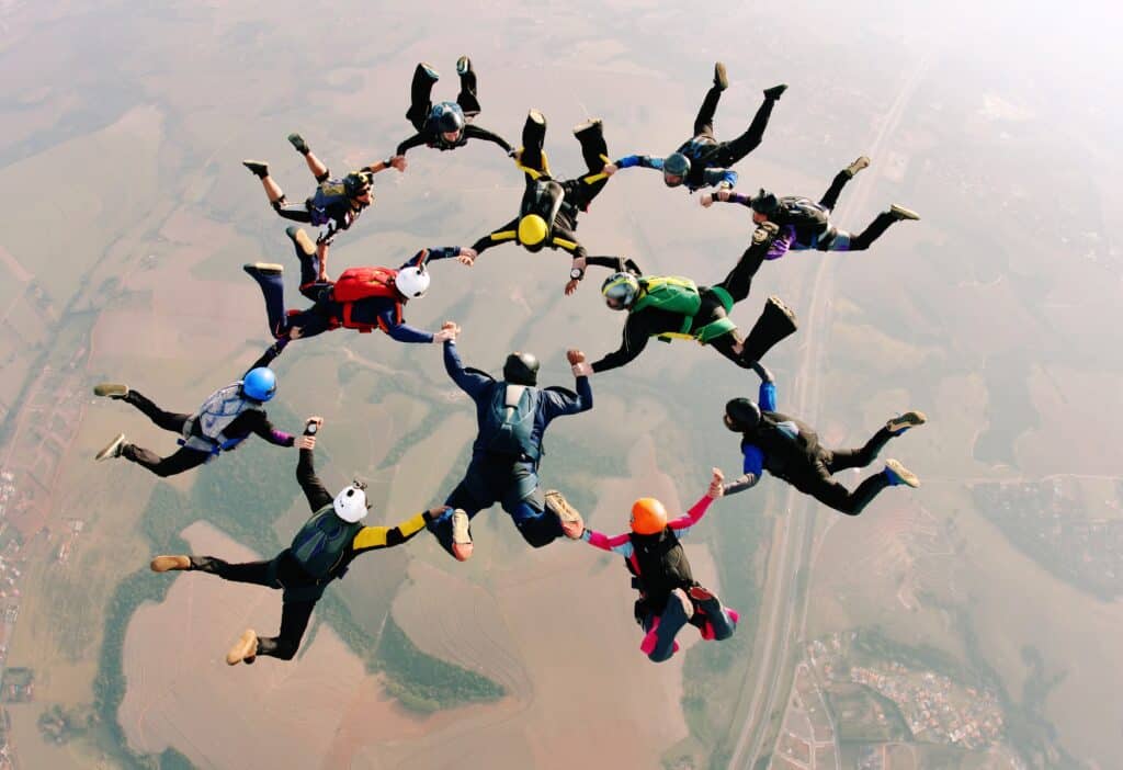 Skydivers holding hands making a formation.
