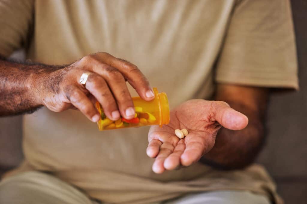 Person pouring pills into their hand
