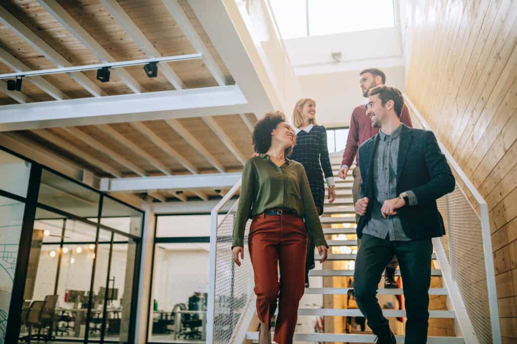 Group of diverse coworkers walking down the stairs in an office