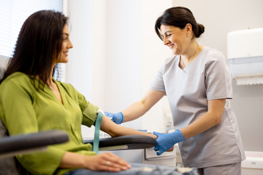 Nurse takes blood test of a young woman in laboratory